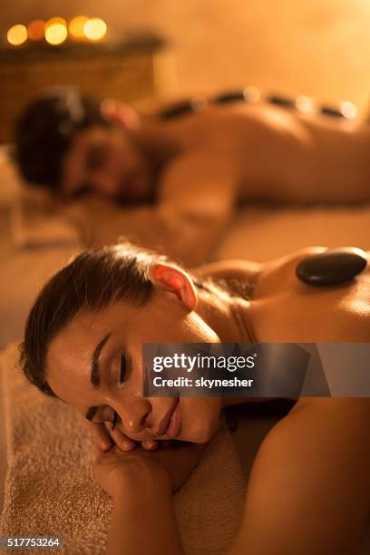 smiling woman enjoying during lastone therapy at the spa. - massage couple stock pictures, royalty-free photos & images