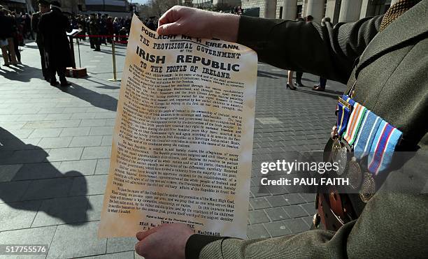 An Irish soldier holds the a copy of the 1916 Proclamation of the Irish Republic outside the General Post Office , the scene of the 1916 Easter...