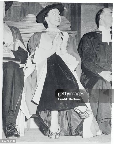 Sadler's Wells prima ballerina Margot Fonteyn, on hand to receive a degree herself, applauds as another personality is honored at London University....