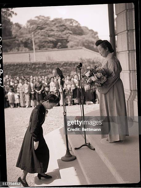 Tokyo, Japan- A Japanese woman, representing the mothers of Japan, is shown at the Imperial Palace in Tokyo, presenting the Empress of Japan with a...