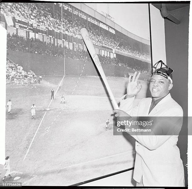 Using a photo mural showing Bobby Thomson's epic homer in 1951, Willie Mays, Giant centerfielder and last year's home run championship, points to the...