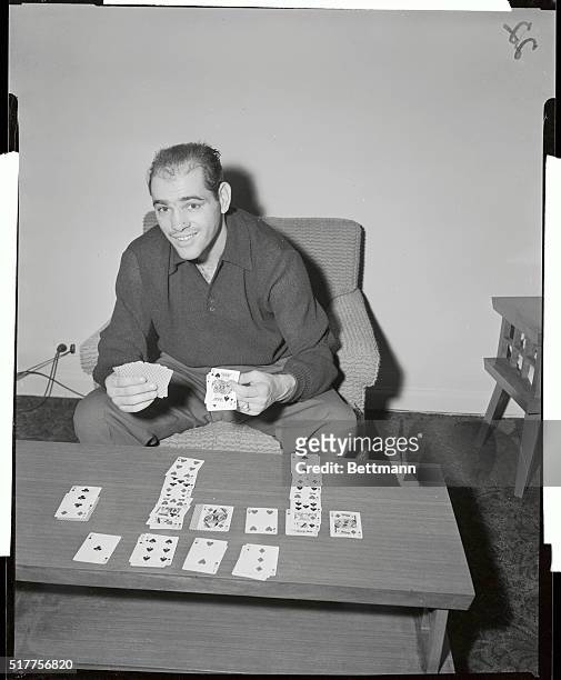 Room for a "King" is uncovered in solitaire game played by Carl "Bobo" Olson, a middleweight boxing champ, as he relaxes from training rigors here....
