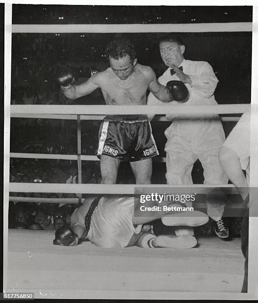 The Italian deaf mute fighter Mario D'Agata looks down here, as dethroned world bantamweight champion Robert Cohen from France hugs the canvas in the...