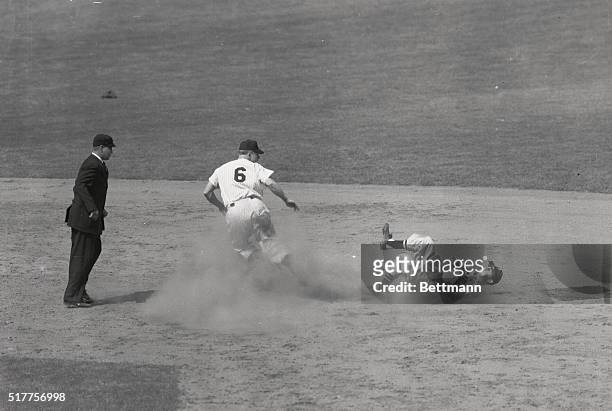 Second baseman Fox of the Chicago White Sox is shown seemingly comfortable on his back, as he takes a bad throw from teammate Masi, while Mantle of...