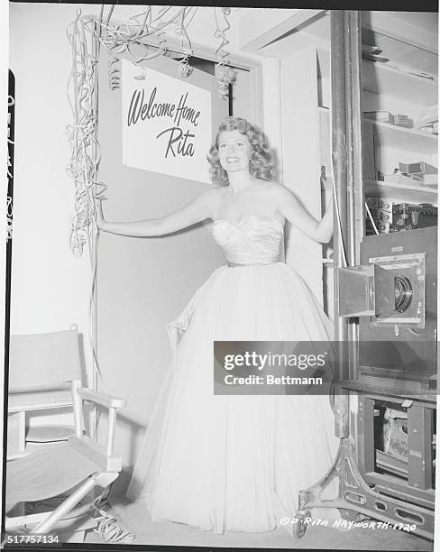 Filmland Welcomes Rita Home. Hollywood, Calif.: Looking her usual glamorous self, Rita Hayworth stands in the doorway of her dressing room on the...