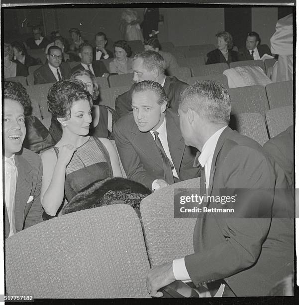 Actor Marlan Brando seldom photographed about town, chats with actress Joan Collins and Cary Grant as they await the opening charity performance of...