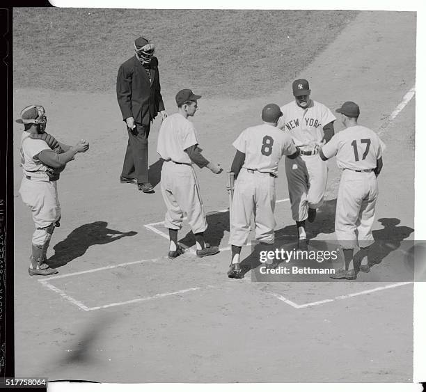 Yankee switcher Mickey Mantle crosses home plate after hitting a mighty two-run homer over the right field fence in the first inning of the world...