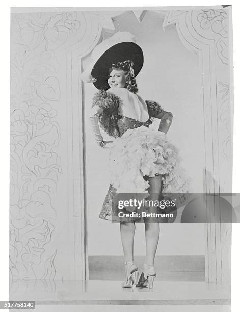 Glamorous film star, Rita Hayworth, lifting her ruffled skirt in the Columbia Pictures 1945 film, Tonight and Every Night.