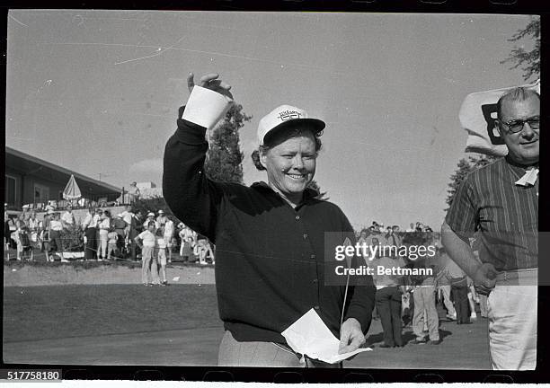 Smiling Patty Berg, of Minneapolis, Minnesota, waves her check of $7,500 after winning the American Women's Open Golf Tourney at the Brookview...