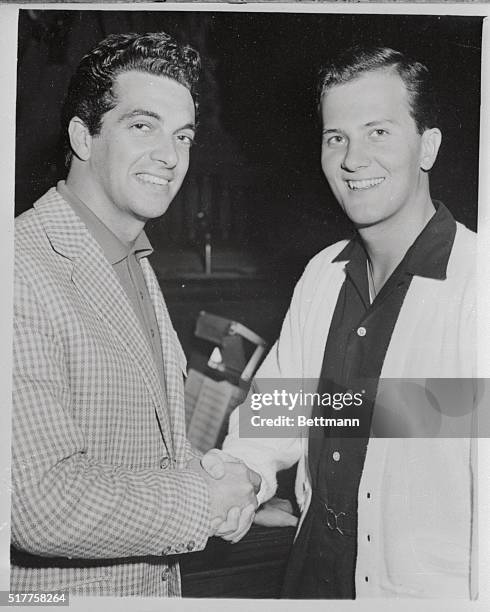 British pop singer Frankie Vaughan meets American singer pat Boone at the London Coliseum this afternoon when they were waiting to rehearse for...