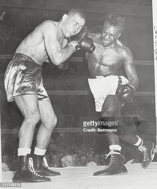 Joe Louis is pictured taking a hard right to the side of the head from Omelio Agramonte in one of the early rounds of their ten-round bout in...