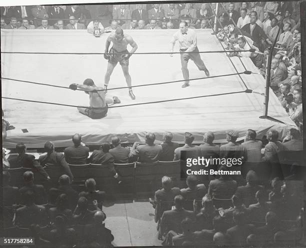 New York: Set For The Count...Referee Ruby Goldstein is shown getting into the act for the count as Joe Louis stands over fallen Lee Savold, after...
