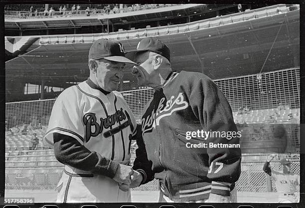 Managers Fred Haney, , of the Braves and Casey Stengel of the Yankees, exchange greetings on field shortly before opening game of 1958 World Series....