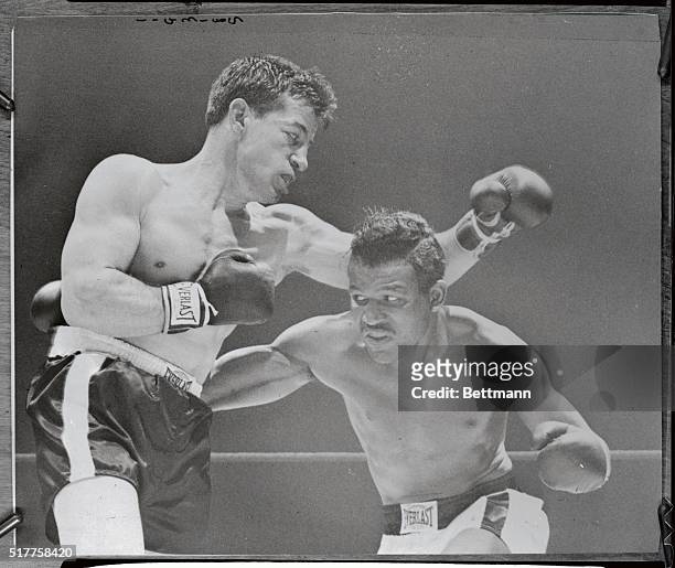 Champion Sugar Ray Robinson works over the midsection of challenger Rocky Graziano, at left, in the second round of a scheduled 15-rounder. Robinson...