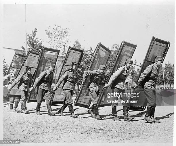 Young Finnish soldiers, shown here, serving their twelve months of military training, are helping to prepare the Olympic Village for the athletics...