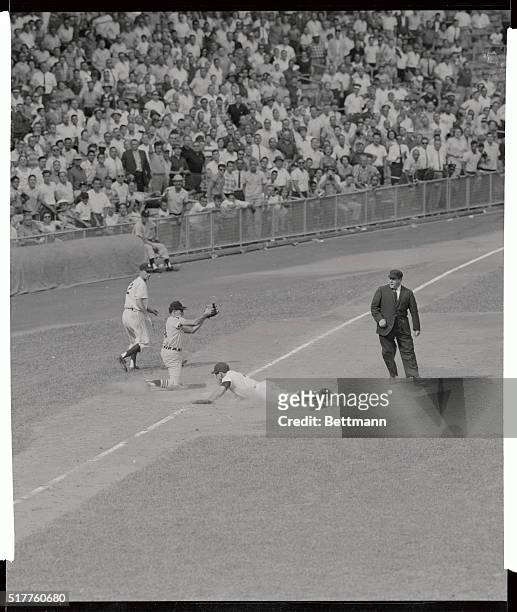 Yankee Yogi Berra hits the dirt as he arrives safely at third base on teammate norm Siebern's single in the ninth inning of New York Chicago game...