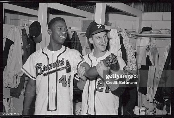 Warren Spahn, Milwaukee Braves left hander, checks the arm of right fielder Hank Aaron who hit a home run in the fourth inning of the Braves-St....