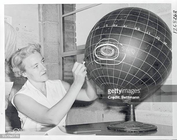 Corona observations here are charted on a black sun globe by Dorothy Trotter, assistant to observatory director. Data yields day-to-day as well as...