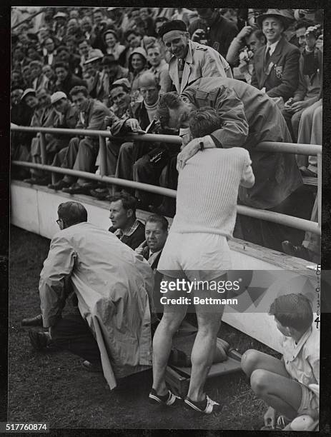 Joseph Barthel of Luxembourg, who won the 1,500 meter event at the Olympics in record time, is hugged by an admirer for his victory. Barthel broke...