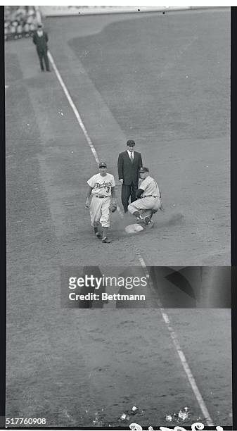 New York: New York Yankees center-fielder Mickey Mantle advances to third base on Dodger Carl Erskine's wild pitch in the Yankees' big sixth inning...