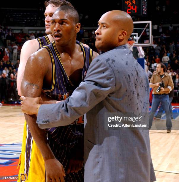 Ron Artest of the Indiana Pacers is restrained by William "Worldwide" Wesley during a melee involving fans during a game against the Detroit Pistons...