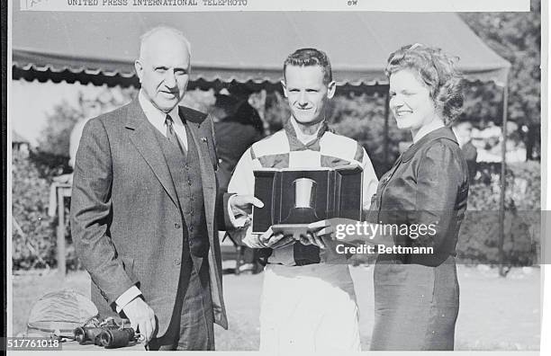 Lexington, Kentucky: Owner Harry Guggenheim and Jockey J. Sellers accepted a gold Julep Cup from Miss Sally Headley after Mr. Guggenheim's 3yo filly...