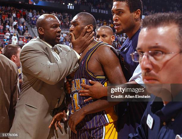 Ron Artest of the Indiana Pacers is restrained during a melee involving fans during a game against the Detroit Pistons November 19, 2004 at the...