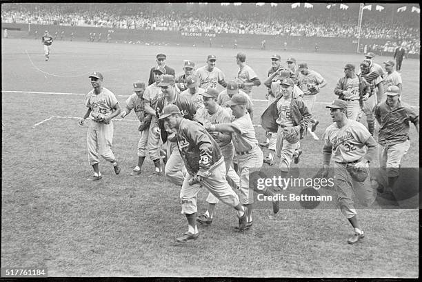 Comiskey Park: Jubilant Los Angeles Dodgers swarm around relief pitcher Larry Sherry after he halted White Sox in another outstanding performance....