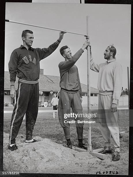 Olympic High Jumpers Walt Davies, , of the U.S.; Alan Peterson, of Great Britain, and Mehnga Singh Sidhu of India, get together to check the high...