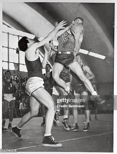 Hot court action is shown in the Olympic basketball clash between Canada and Italy at Helsinki's Tennis Palace here. R.J. Phibbs, , of Canada, has a...
