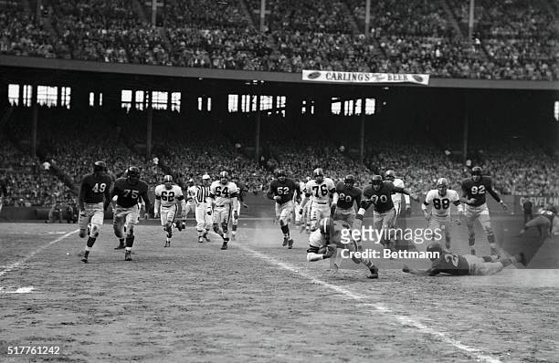 Cleveland Browns' Otto Graham goes down, pigskin still clutched in his arm, after gaining 5-yards on a quarterback sneak in the third quarter of...