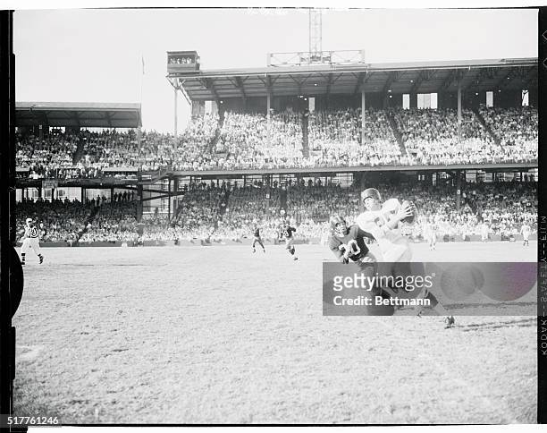 Bob Schnelker Giant end, takes the second touchdown pass from his quarterback Charlie Conerly in the second quarter of today's Redskins-Giants game....