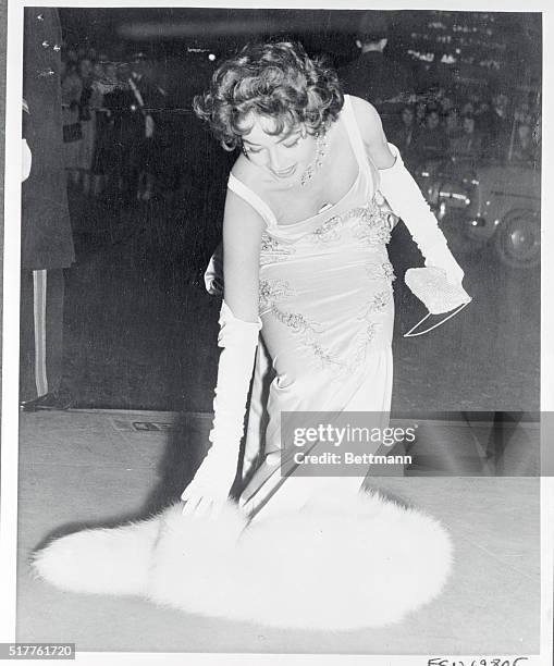Mara Lane had to scoop up her fur piece in the absence of a beau brummel as she arrived for the royal command performance of the film Beau Brummell...