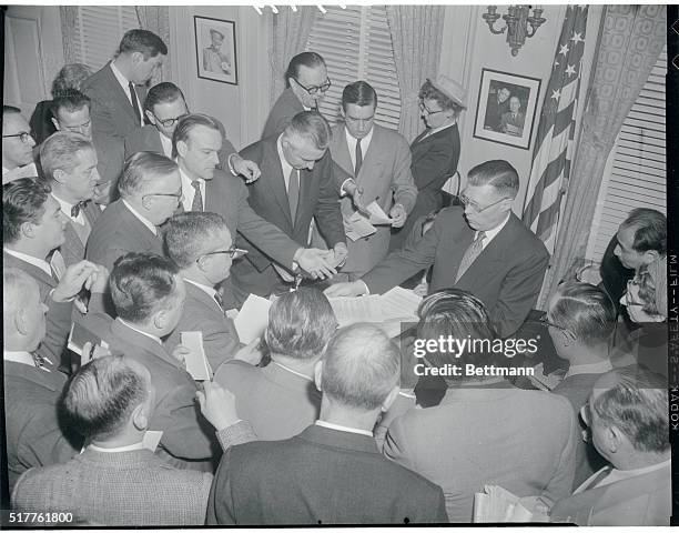 White House Press Secretary James Hagerty, right, is shown handing out to White House newsmen copies of President Eisenhower's special message to...