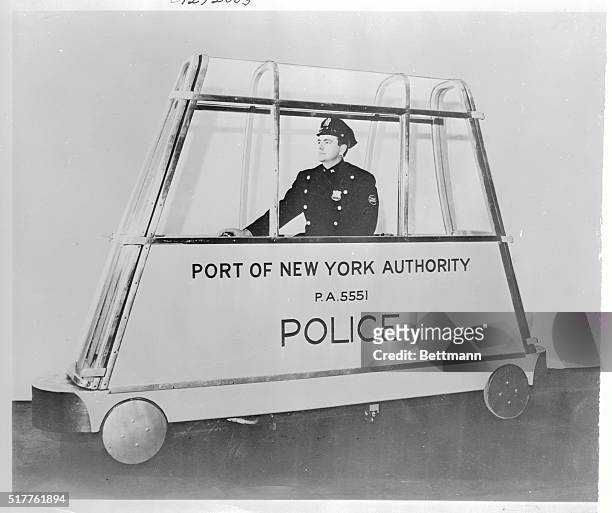 An officer of the New York Port Authority is shown at the controls of the new two-way plastic enclosed catwalk car which made its first test run on a...