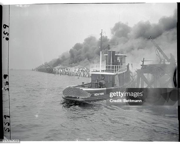 New York Police boat heads directly into the inferno created by the crash of an Italian Airlines plane in the Bay off Idlewild Airport. Of the 32...