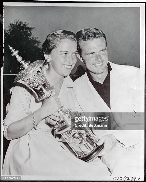 Harvie Ward and his attractive wife, Susan, beam happily as they cuddle the trophy symbolic of the National Amateur Golf Championship after Ward won...