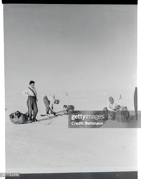 Adjusting rucksacks and skis, members of the U.S. Air Force unit at Thule prepare to take off on exploration of the frozen wastes. The base is a key...