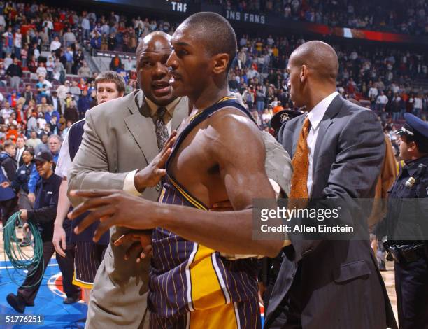 Ron Artest of the Indiana Pacers is restrained during a melee involving fans during a game against the Detroit Pistons November 19, 2004 at the...