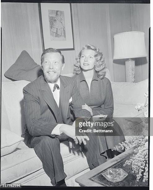 Sporting a new beard and mustache, crooner Dick Haymes poses with his glamorous wife, Rita Hayworth, at a press conference that marked their return...