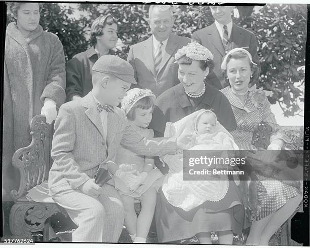 David Eisenhower, age 8, chucks his sister, Mary Jean, age 3 mos., under the chin while his other sister, Susan, age 3 1/2, watches along with her...