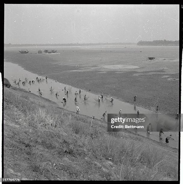 Fish don't stand a chance as Laotian villagers converge on a shallow finger of the Mekong River, near Vientiane. The fisherman, mostly women, use big...