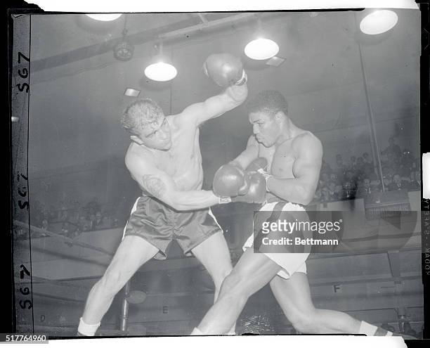 New York: Center Bloc--Middleweight Rory Calhoun, , blocks a right to the midriff as Jackie La Bua's left trails off overhead. Action was in the...