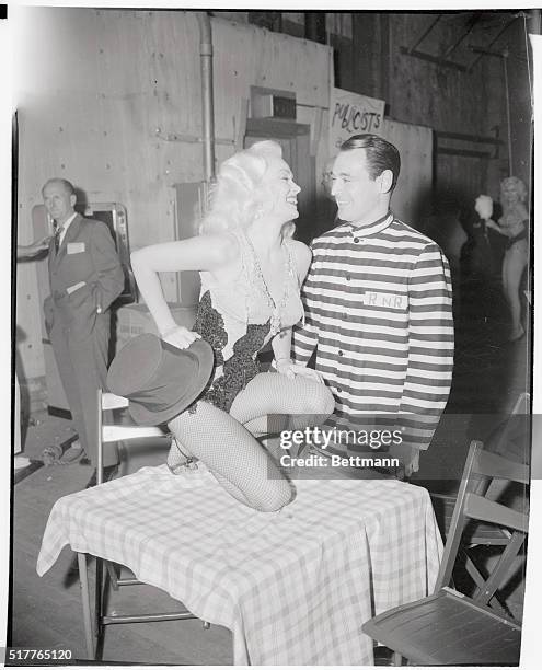 Ray Anthony dressed as a convict and his wife Mamie Van Doren in a show girl costume are shown enjoying themselves at the Ballyho Ball given by the...