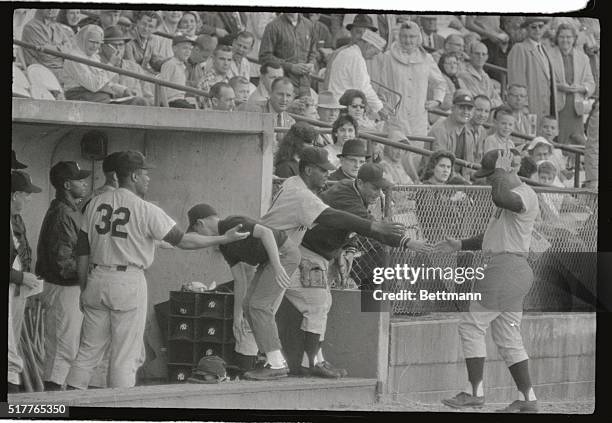 Roger Maris of the New York Yankees watches his first homer of spring training exhibition games go over the right field fence in first inning of game...