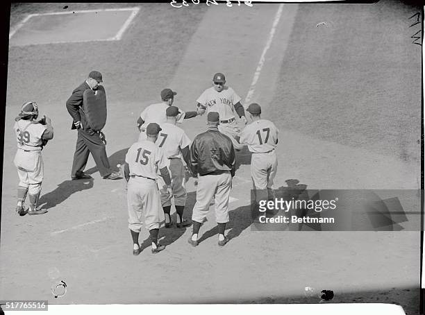 Mighty Yogi Berra of the Yankees is shown being welcomed home after his Homeric clout with bases loaded in the second inning of the second World...