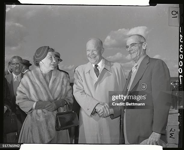 Happily anticipating his first round of gold after arrival in Augusta, President Eisenhower shares a hearty laugh with the first lady and Cliff...