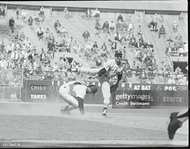 Up and Over. New York: White Sox' Luis Aparicio swings his leg over the head of Yankee Bill Skrowon during a force out play at second during their...