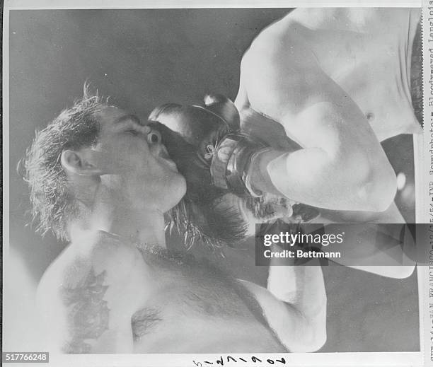 Middleweight Champ Carl Olson, left, who scored a TKO over French challenger Pierre Langlois last night in their title bout, appears to be using his...