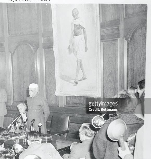 Standing in front of a portrait of the late Mahatma Gandhi, in India House, London, Pandit Jawaharlal Nehru, Prime Minister of India is shown as he...